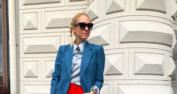 Emilia De Poret står i röda byxor och blå kavaj under Modeveckan 2018